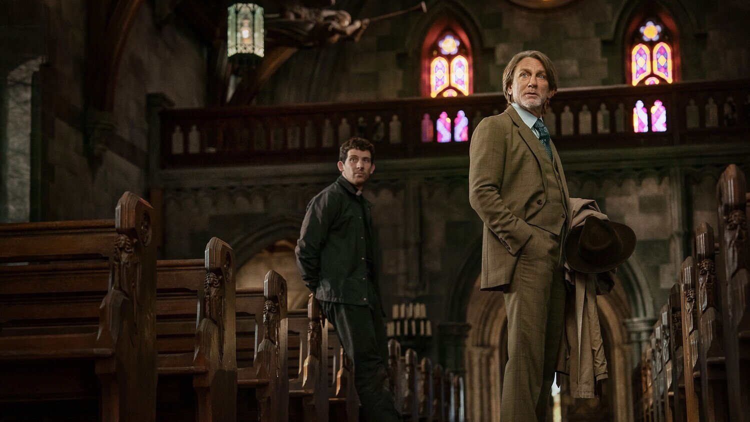 кадр из фильма "Достать ножи: Воскрешение покойника", в кадре: Джош О’Коннор - Fr. Jud Duplenticy, Дэниэл Крэйг - Benoit Blanc